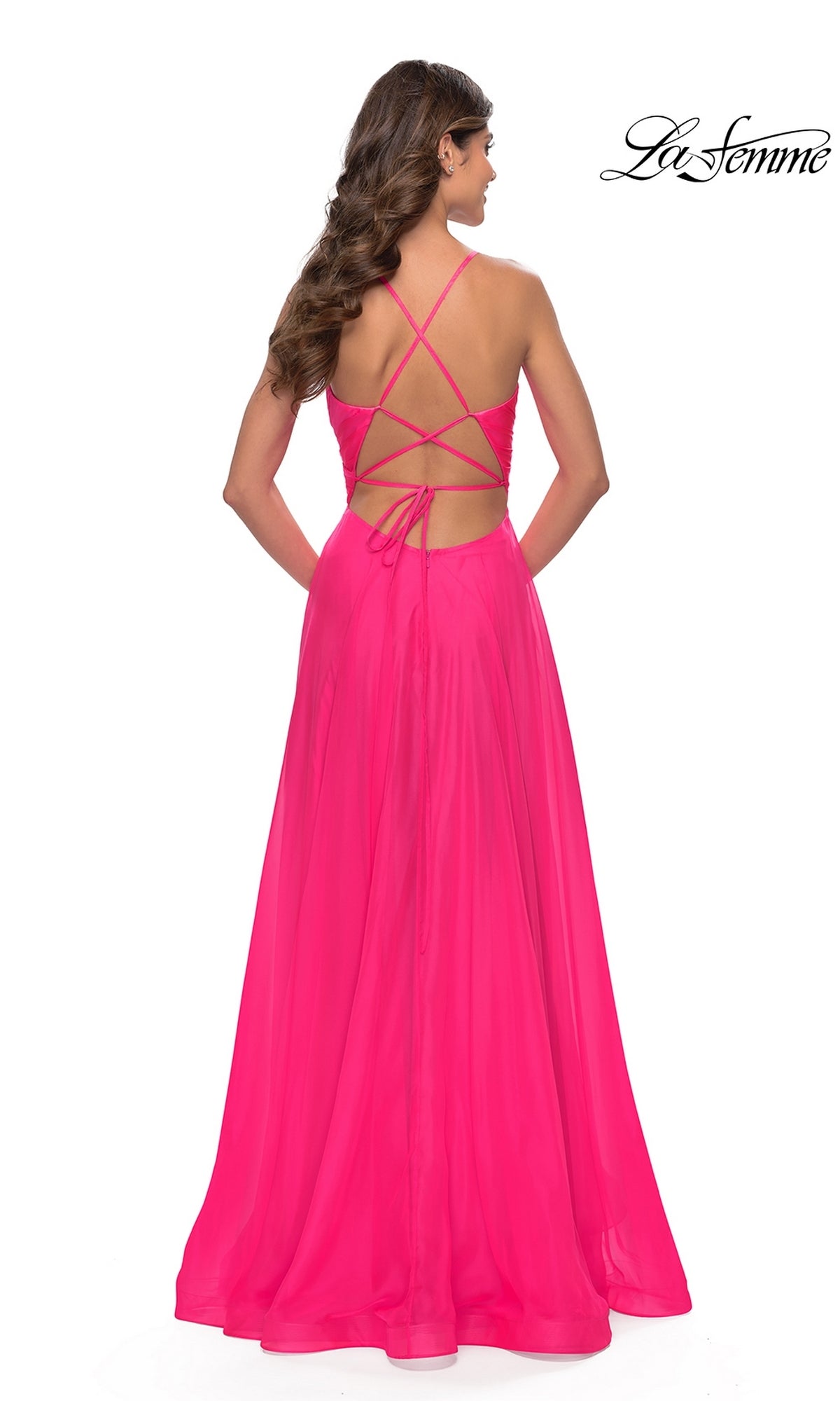 A woman is seen from behind in the La Femme V-Neck Long Tulle Prom Ball Gown 30840, featuring a bright pink color, crisscross open back, and flowing skirt. The La Femme logo is displayed in the top right corner.